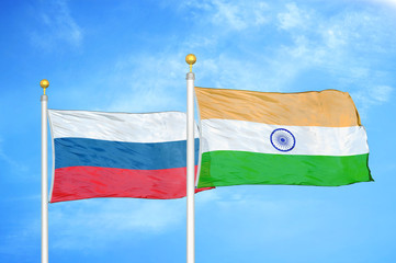 Russia and India two flags on flagpoles and blue cloudy sky