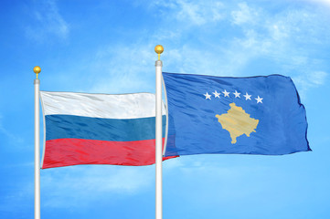 Russia and Kosovo two flags on flagpoles and blue cloudy sky