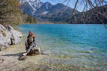 Fototapeta premium Frau am See Natur Bergsee Wanderung sitzt am Fels sitzend jung sportlich attraktiv