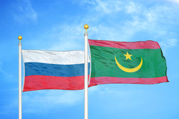 Russia and Mauritania two flags on flagpoles and blue cloudy sky