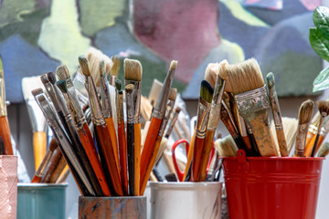 Brushes are in a glass in the artist's Studio
