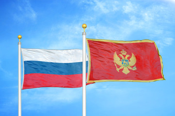 Russia and Montenegro two flags on flagpoles and blue cloudy sky
