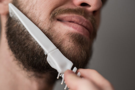 A man combing his beard with a comb