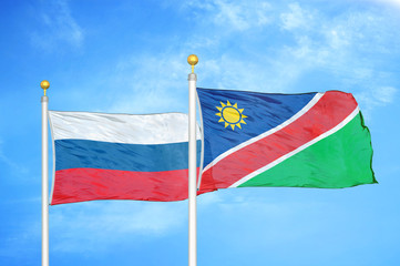 Russia and Namibia two flags on flagpoles and blue cloudy sky