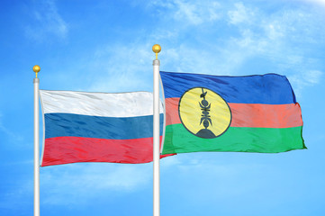 Russia and New Caledonia two flags on flagpoles and blue cloudy sky