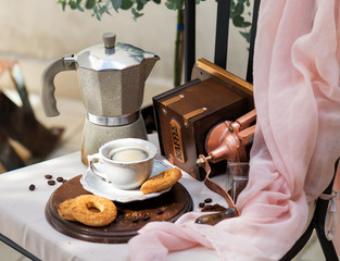 morning coffee with biscuits, Morning coffee in the backyard. Cup with fresh coffee, cookies, mocha and a coffee grinder on a chair, Italian still life, good day