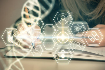 Double exposure of woman hands typing on computer and DNA hologram drawing. Medical education...