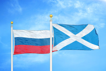 Russia and Scotland two flags on flagpoles and blue cloudy sky