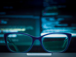 glasses and screen with code in background 