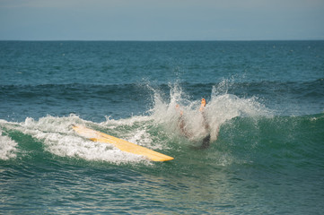 Young people ride on short boards, perform bright tricks on the waves during sunset.