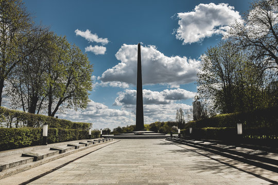 Black tower with clouds in background