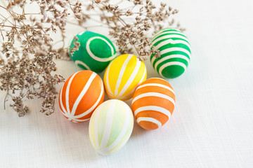 Brightly colored Easter eggs are lying on the table. Spring holiday