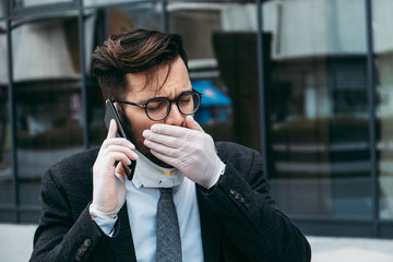 Sick man with protective face mask coughing and sneezing on street. Virus pandemic or epidemic concept.