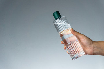 Woman holding Turkish cologne (or eau de cologne) on her hand. Coronavirus transmission with hands. Covid19 concept