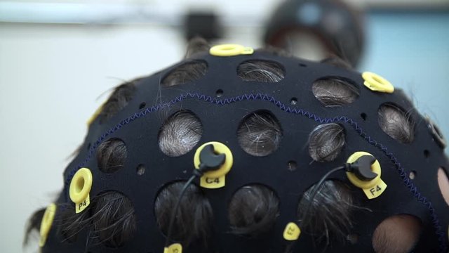 Doctor preparing man for brain scan in hospital. The installation of the sensors for the EEG of the brain