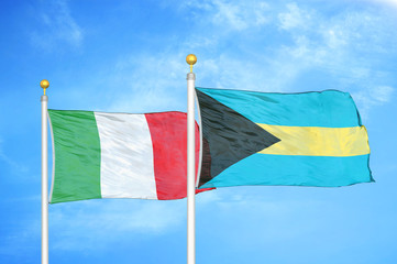 Italy and Bahamas  two flags on flagpoles and blue cloudy sky