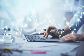 Double exposure of woman hands typing on computer and forex chart hologram drawing. Stock market...