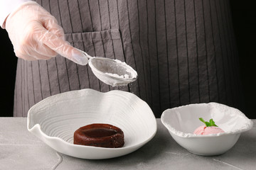 Chef decorating delicious fresh chocolate fondant. Lava cake recipe