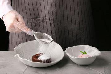 White plate with chocolate fondant close up. woman hands. chef make dessert. Lava cake recipe