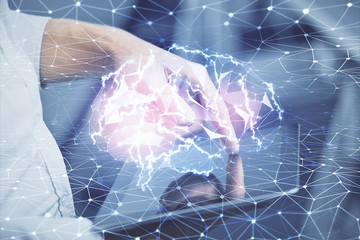 Double exposure of man's hand holding and using a digital device and brain hologram drawing. Data...