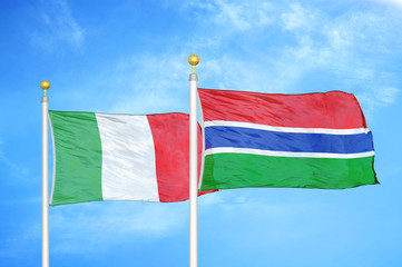 Italy and Gambia two flags on flagpoles and blue cloudy sky