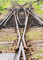 train tracks crossing on grass ground