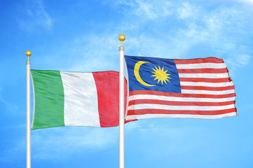 Italy and Malaysia two flags on flagpoles and blue cloudy sky