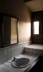 old rustic style bathroom with window through which natural light enters