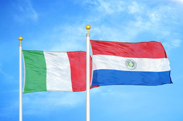 Italy and Paraguay two flags on flagpoles and blue cloudy sky