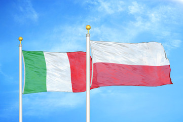 Italy and Poland two flags on flagpoles and blue cloudy sky