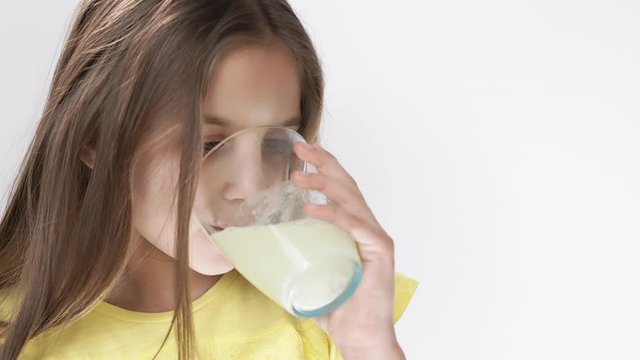 little girl throws a tablet with vitamins that dissolve in water. The girl drinks fizzy medicine.
