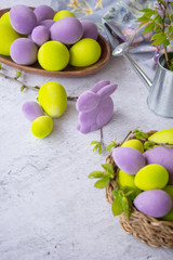 easter green and purple eggs with rabbit on a light surface
