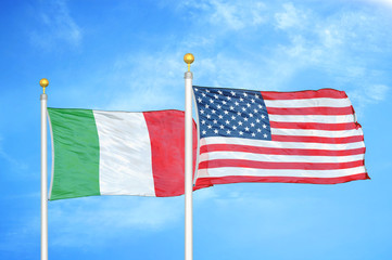 Italy and United States two flags on flagpoles and blue cloudy sky