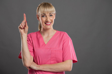 Portrait of young attractive female nurse making good idea gesture