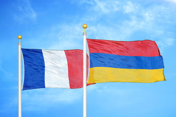 France and Armenia  two flags on flagpoles and blue cloudy sky