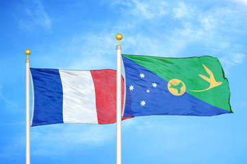 France and Christmas Island two flags on flagpoles and blue cloudy sky