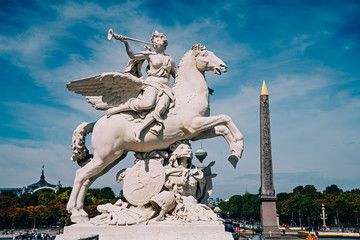 Angel on horse statue with Luxor Egyptian obelisk in the background at the Place de la Concorde in Paris, France