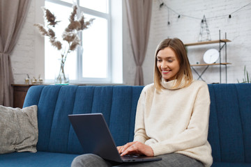 Working from home.Communication online with colleagues and freelancers.Portrait of young female freelancer using laptop and smiling. Concept of young people working with mobile devices.