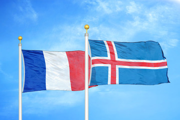 France and Iceland two flags on flagpoles and blue cloudy sky