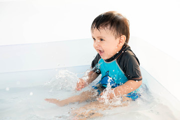 Baby smiling and enjoying the water in a swimming pool