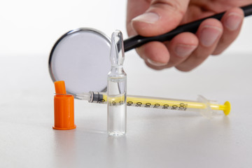 Insulin syringe with vial on a light table.