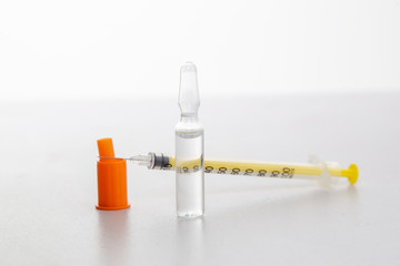 Insulin syringe with vial on a light table.