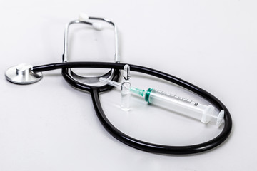 Phonendoscope and syringe on a white background.
