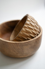 Wooden utensils for food on a white isolated background. Handcrafted natural bowl plates from an expensive variety of wood. Empty round tray plate. Eco-friendly cookware.