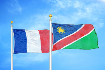 France and Namibia two flags on flagpoles and blue cloudy sky