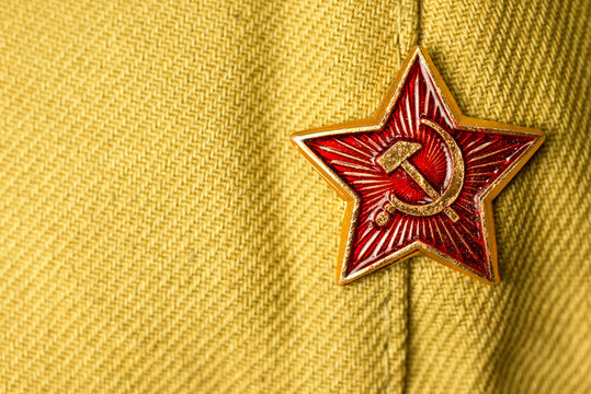 Old soviet military badge with hammer and sickle on light green cloth headgear. Red five-pointed soviet  communist gold red star. Symbol of the USSR. Space for the text. Victory Day Concept.