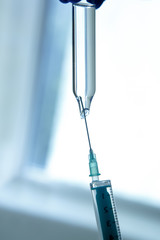 A medical worker dials medicine into a syringe .