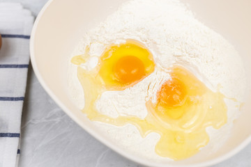 Top view of smashed eggs in flour ready for creating dough
