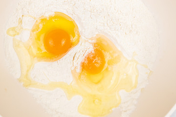 Top view of smashed eggs in flour ready for creating dough