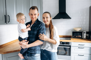 Happy family. Portrait of an amazing family, dad mom and their beloved little son, at their cozy kitchen
